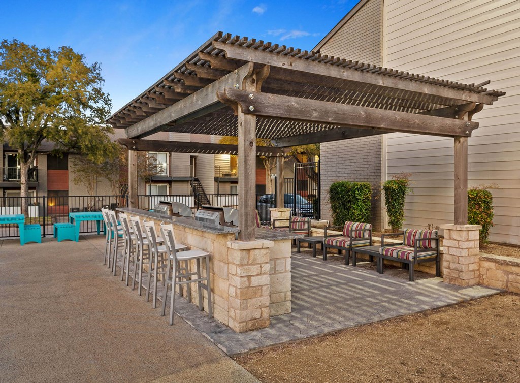 a patio with a bar and chairs in front of a house a patio with a bar and chairs in front of a house at South Lamar Village, Austin, Texas